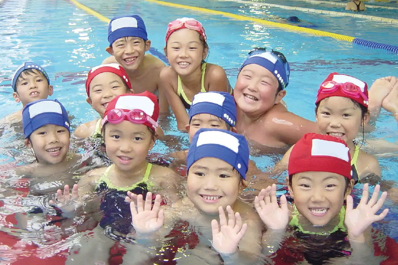 子供たちがプールで楽しそうに泳いでいる様子